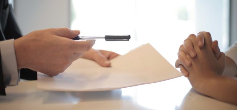 person handing pen over contract