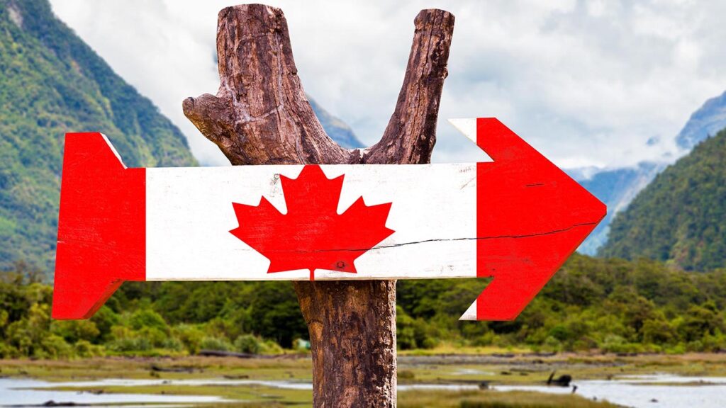 a wooden arrow decorated in the style of a Canadian flag