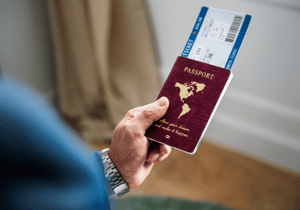Man Holding Passport and Plane Ticket
