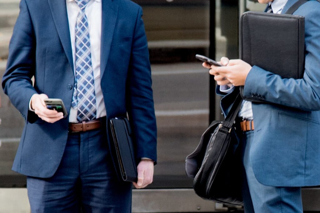 two businessmen outside on their phones