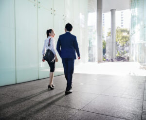Asian business people discussing while walking