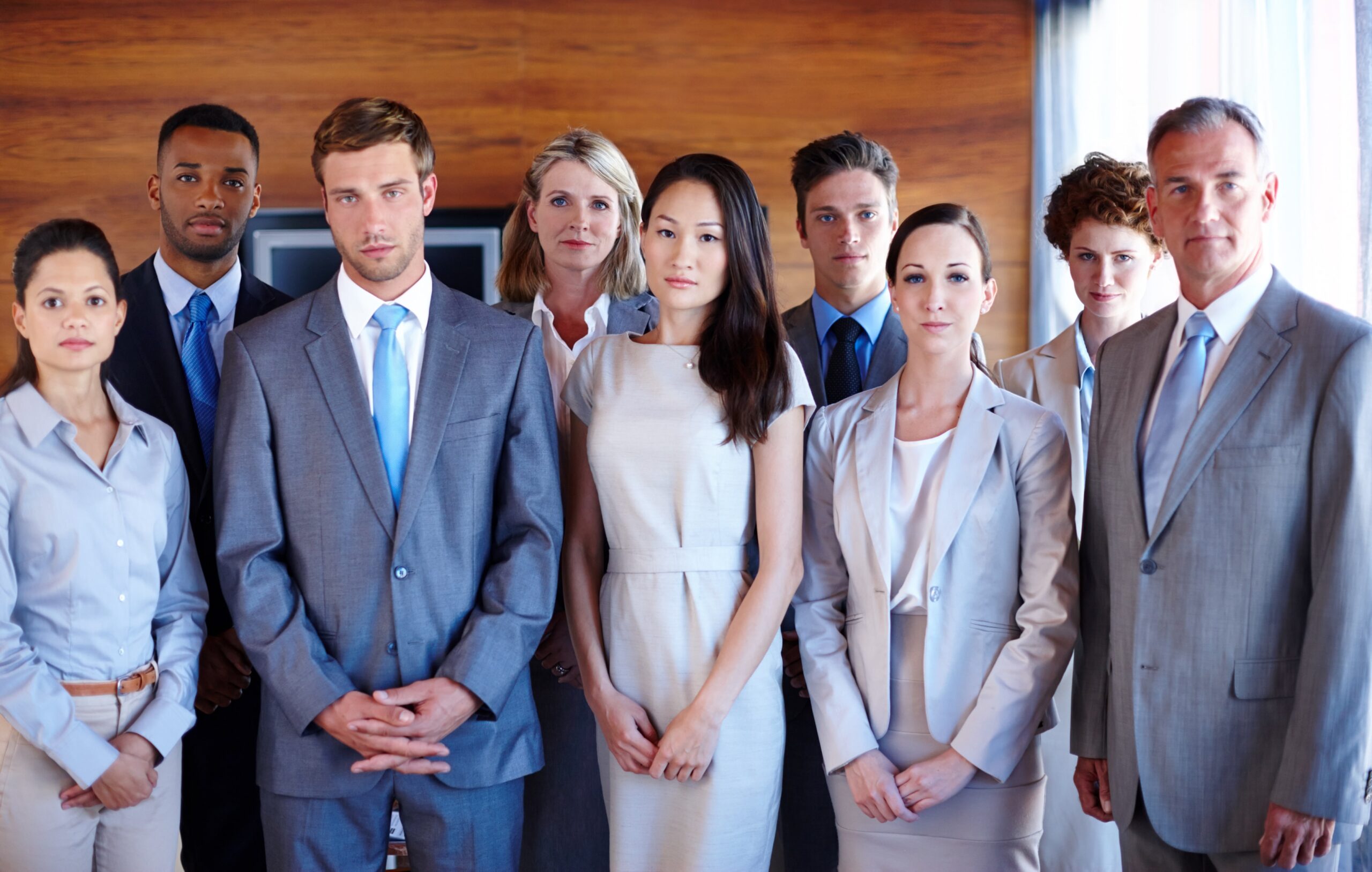 A serious and diverse group of people looking directly at the camera, representing immigrant entrepreneurs in Canada navigating policy changes without prior notice and committed to complete their vision.
