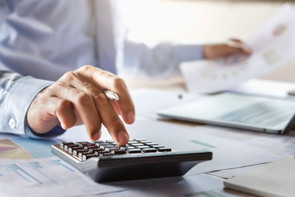 Man calculates costs and reviews requirements for an open work permit application, including labour market impact assessment details, expiry date of current work permit, and financial proof from his home country.