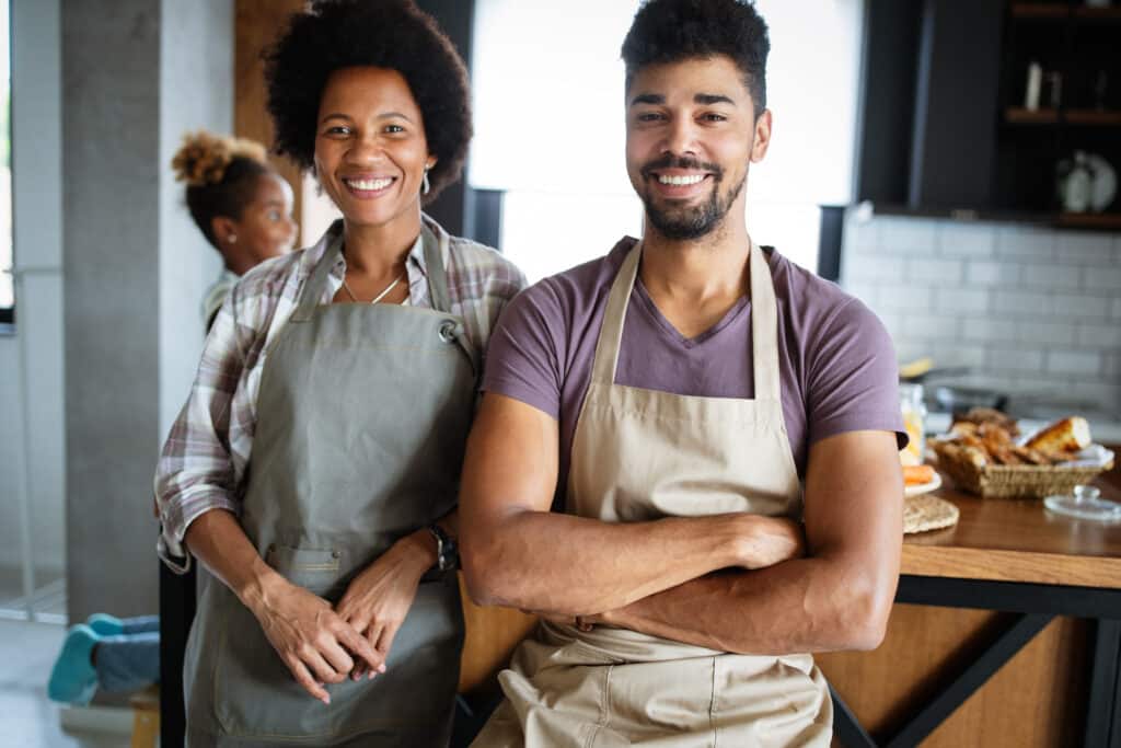 Happy self-employed couple celebrating C11 work permit approval after launching successful business in Canada contributing to local economy